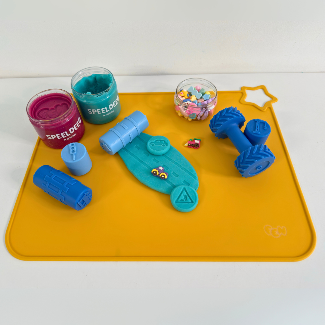 Gele placemat met Op-de-Weg stempels en blauwe wielen; racebaan in Fen-speeldeeg