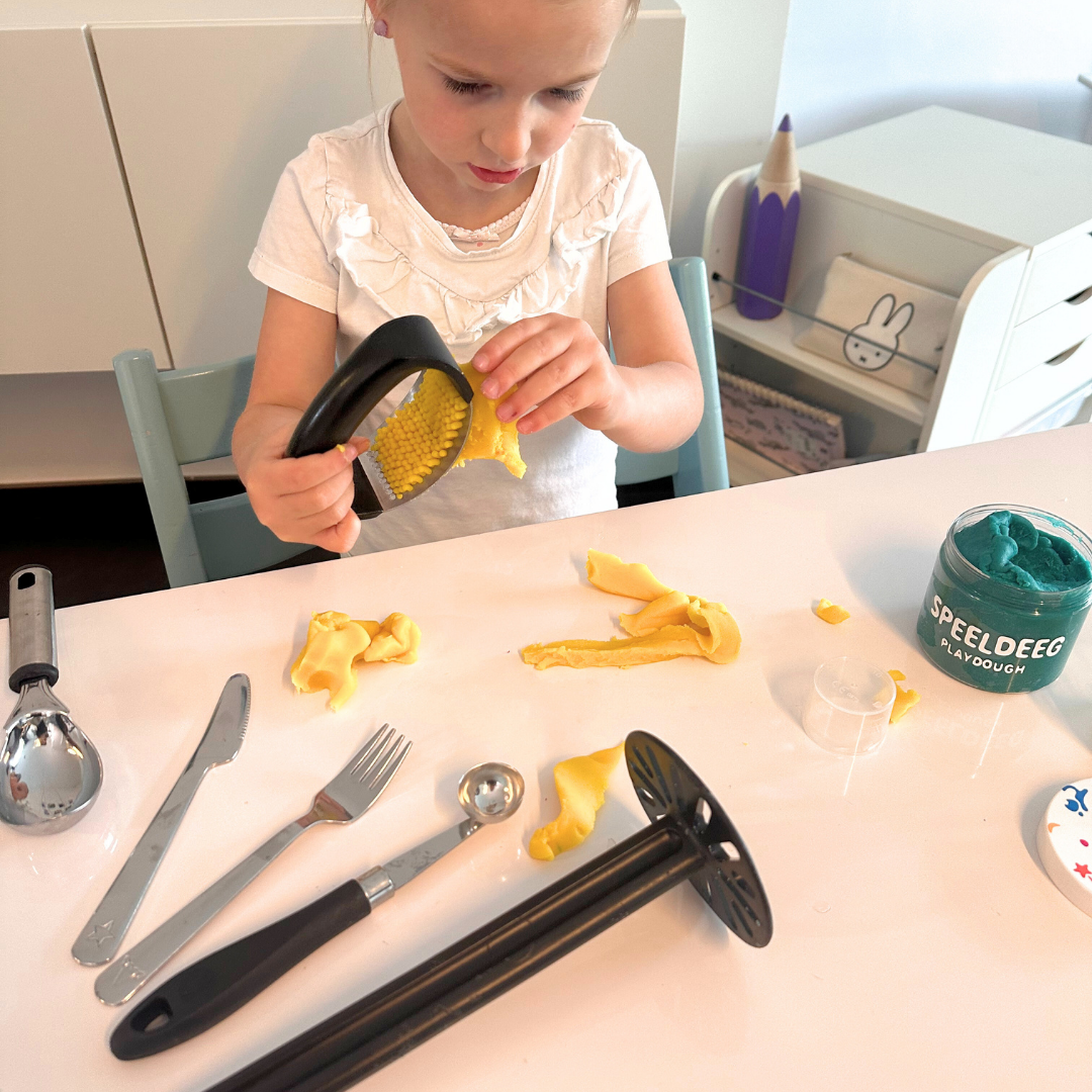 Kind speelt met speeldeeg en kosteloze materialen uit de keuken. 