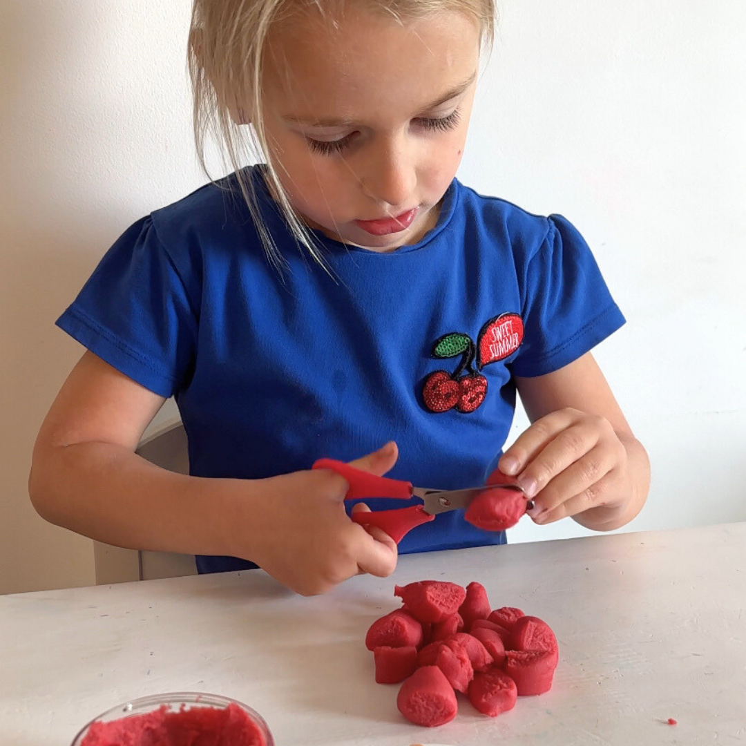 Knippen in speeldeeg om de fijne motoriek te verbeteren. 